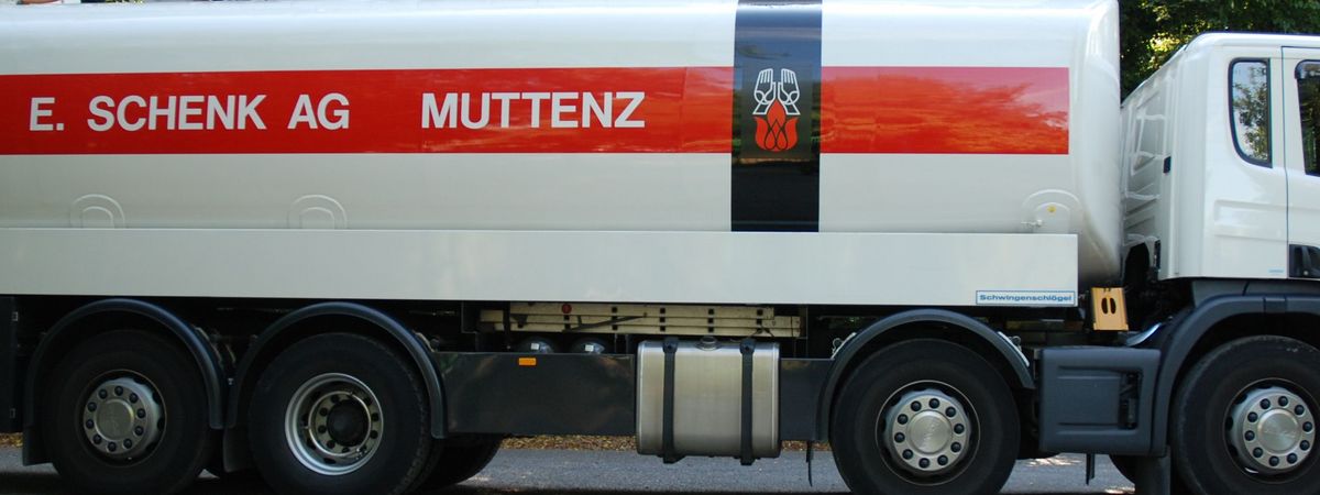 Der Heizöllieferwagen der Firma E. Schenk AG auf einem Parkplatz inmitten von Bäumen